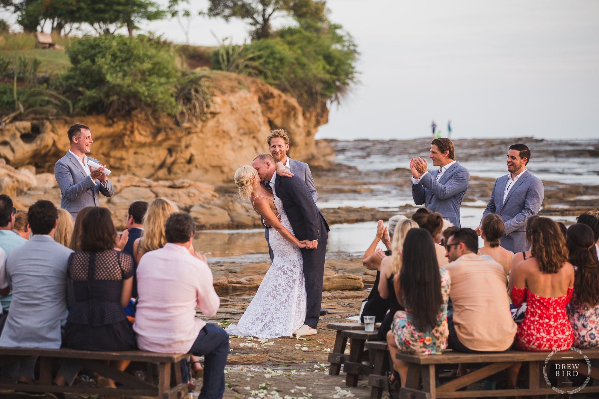 Intimate wedding ceremony on tidal rocks on the beach at sunset. Rancho Santana Nicaragua destination wedding photographer Drew Bird.