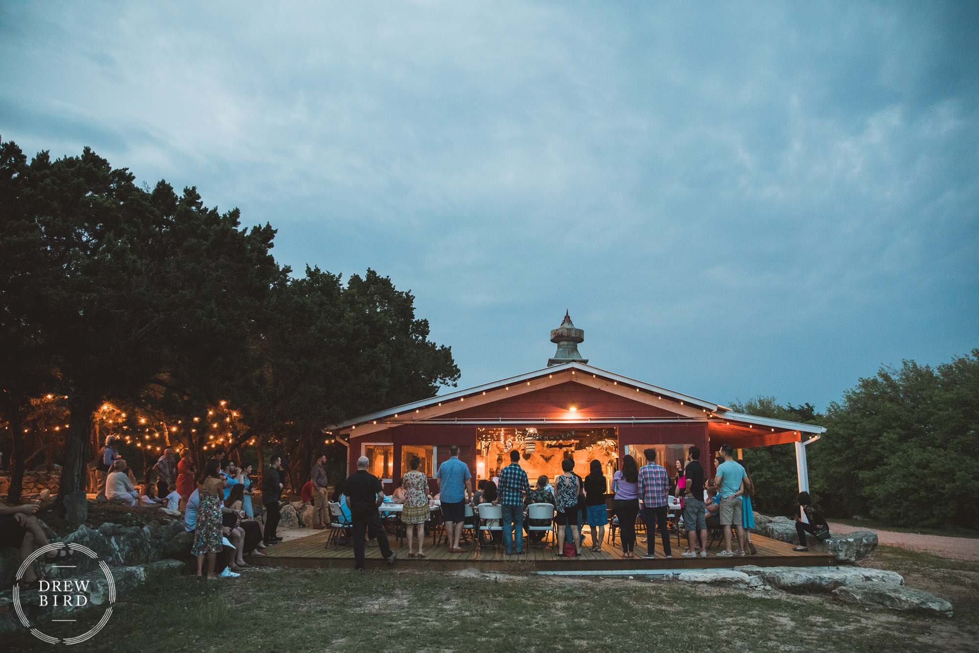Rustic barn wedding welcome party at sunset. Speeches for a destination wedding photography story in Austin Texas.