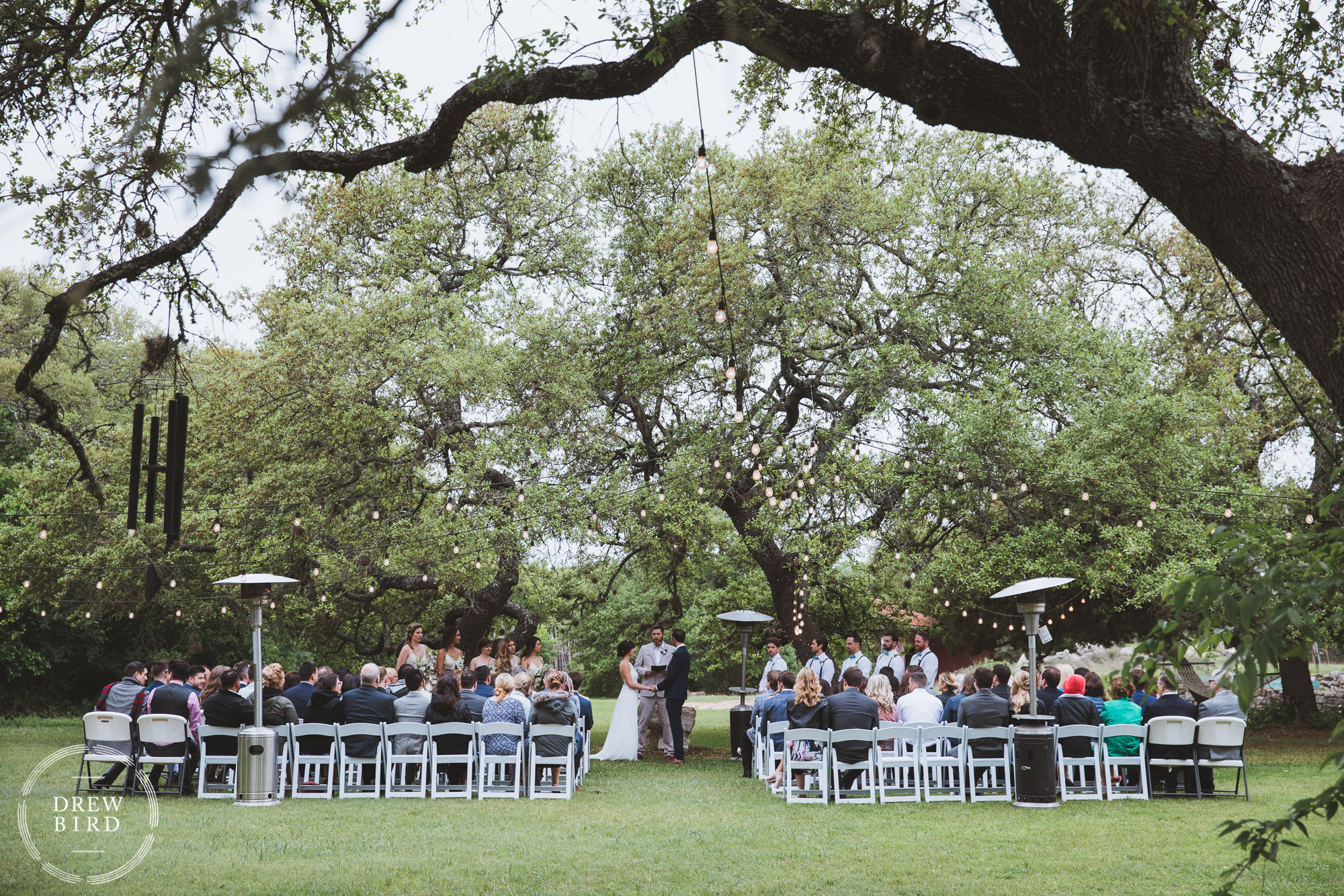 Wedding ceremony under trees at rustic texas ranch. Austin Texas ranch wedding. Travel and destination wedding photographer Drew Bird.