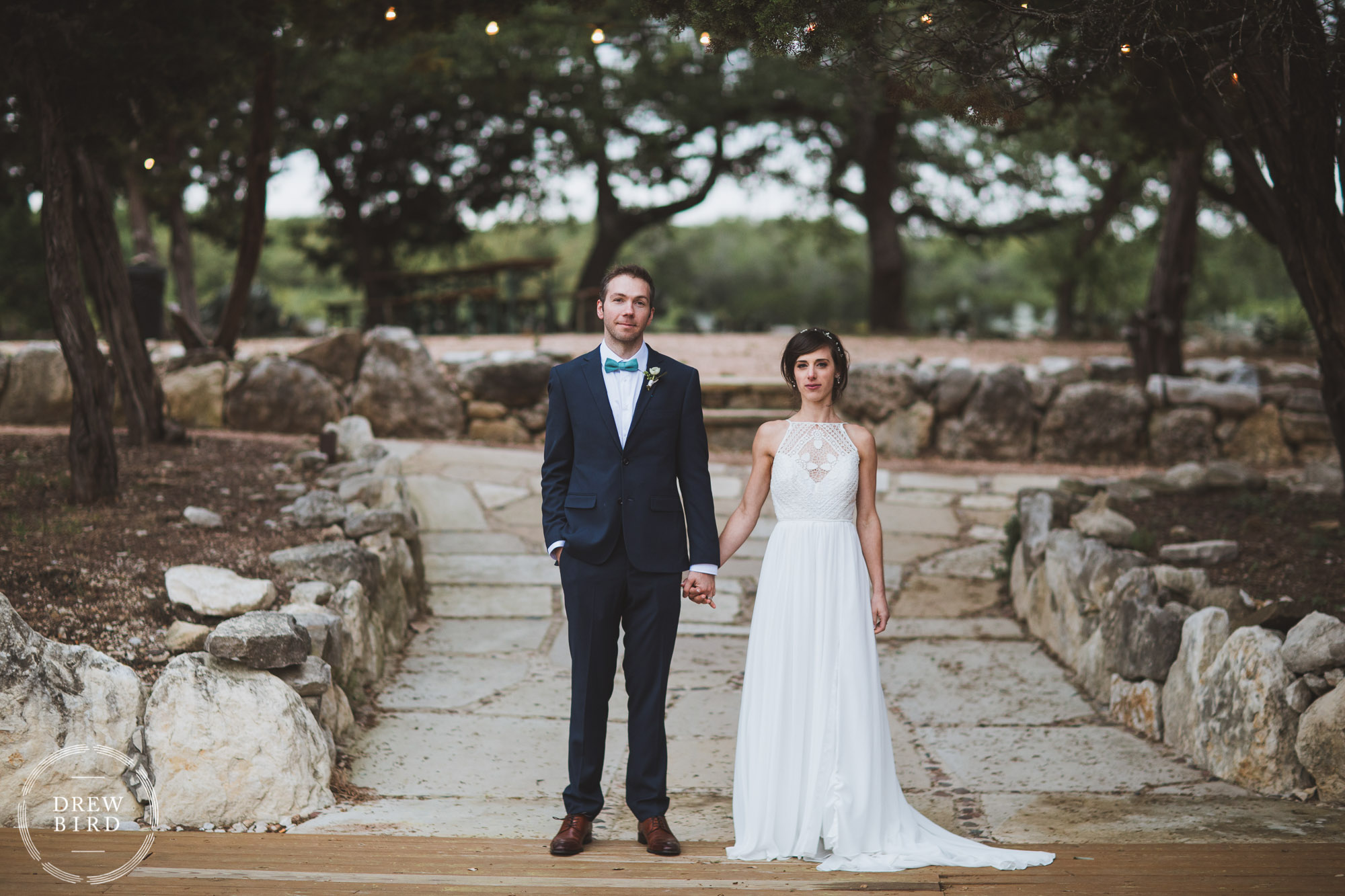Bride and groom wedding portrait in front of a rock wall and path. Austin Texas ranch wedding.