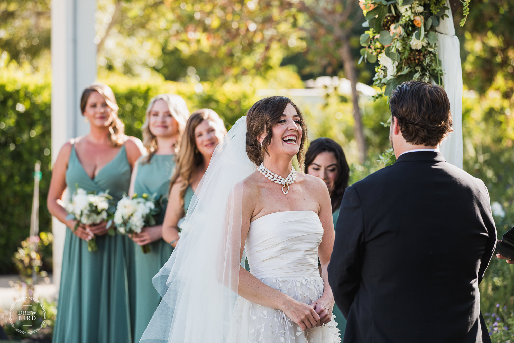 Bride laughing during ceremony. Solage Auberge Resort wedding venue in Napa, California.