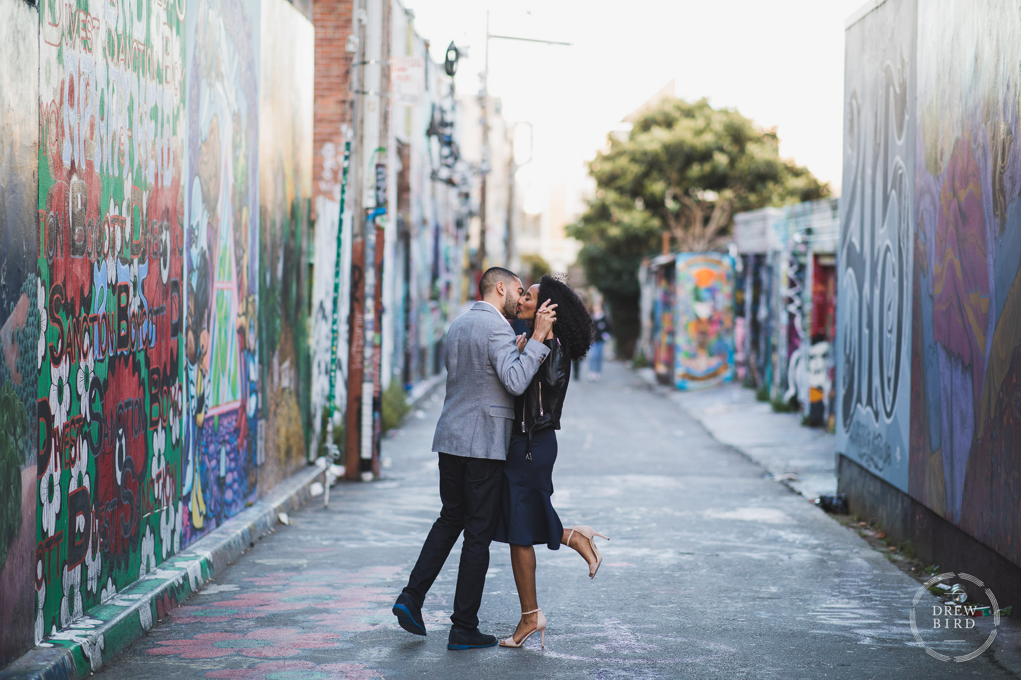 Clarion Alley engagement wedding photo in San Francisco with engaged couple kissing. Urban engagement shoot by Drew Bird.