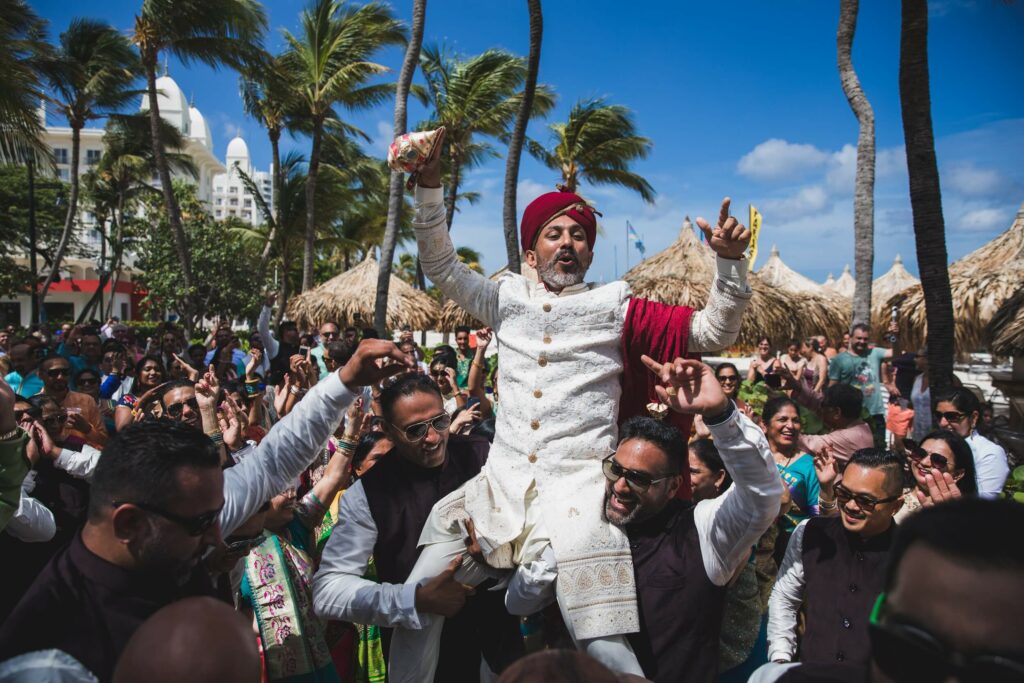 the groom is carried by guests during a sikh wedding