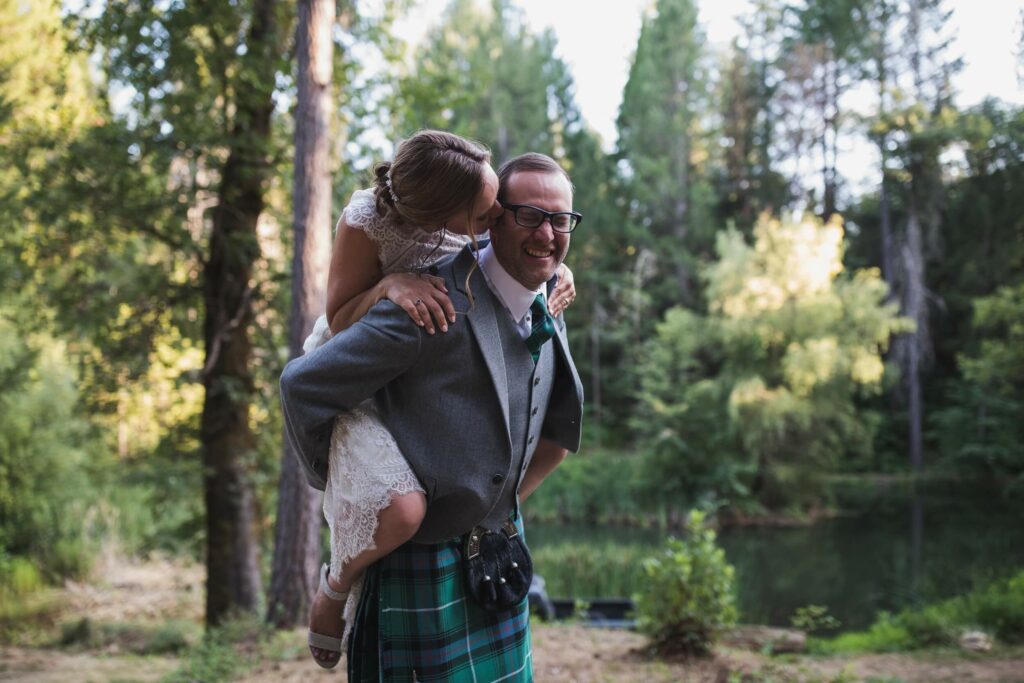 groom carries his bride on his back after they exchange vows at their wedding ceremony