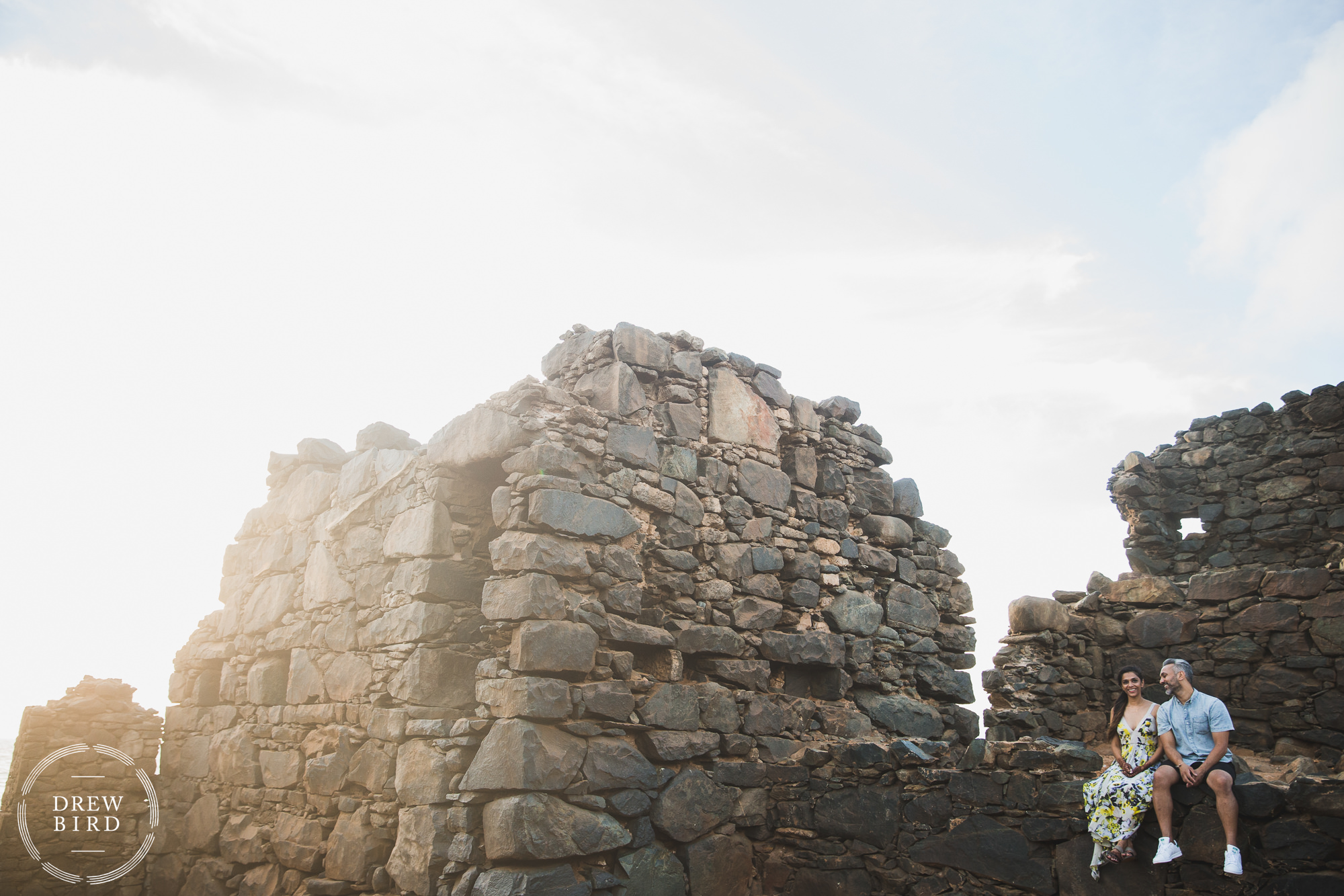 Indian wedding couple sitting on ancient ruins praying at sunrise for destination wedding photography by Drew Bird.
