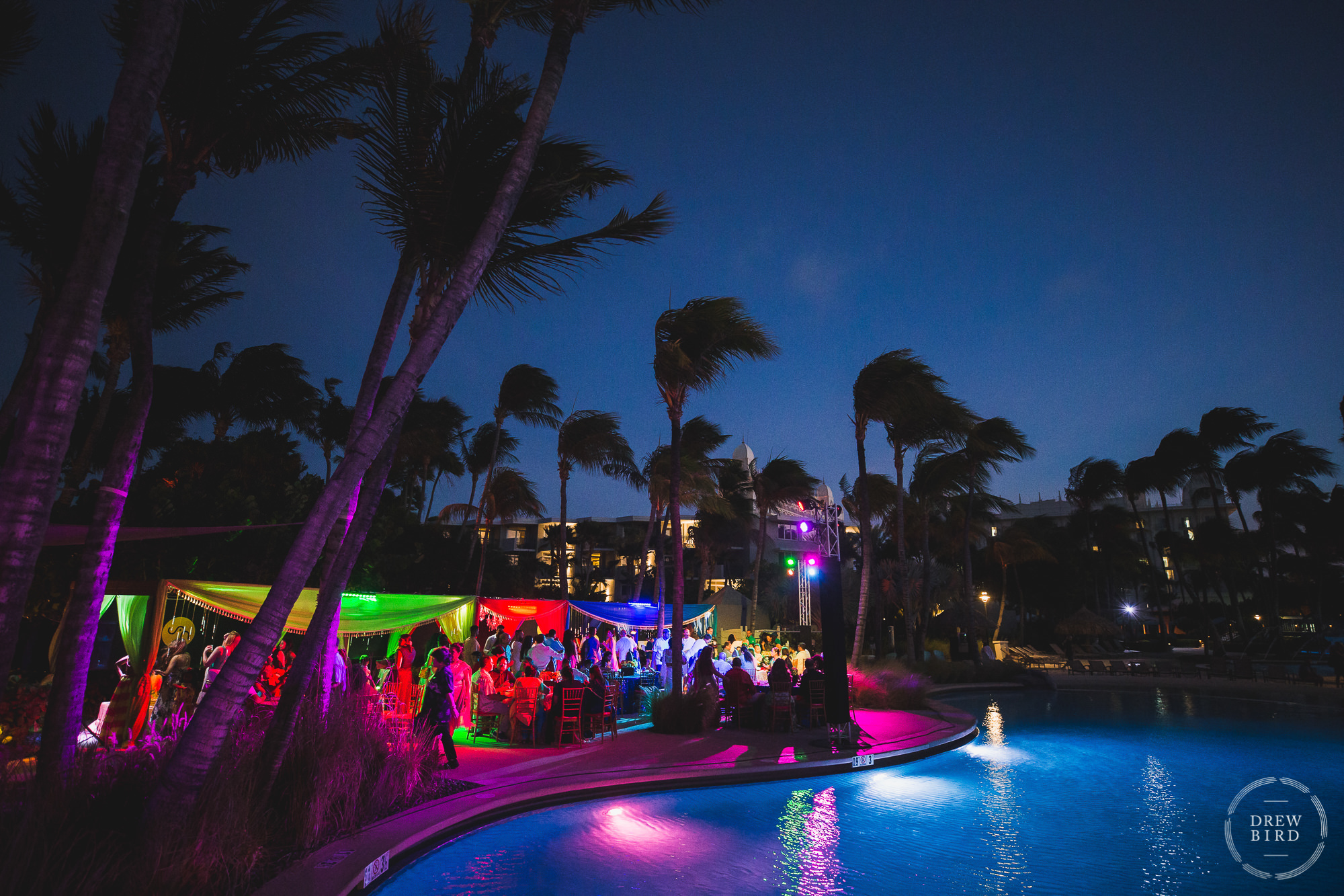 A beautiful long-exposure that shows the pool and the colorfully lit welcome party for a five day destination Indian-Hindu wedding at the Aruba Hilton Resort on the Caribbean island of Aruba.